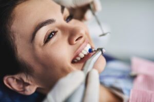 Woman having her teeth cleaned at dentist’s office.